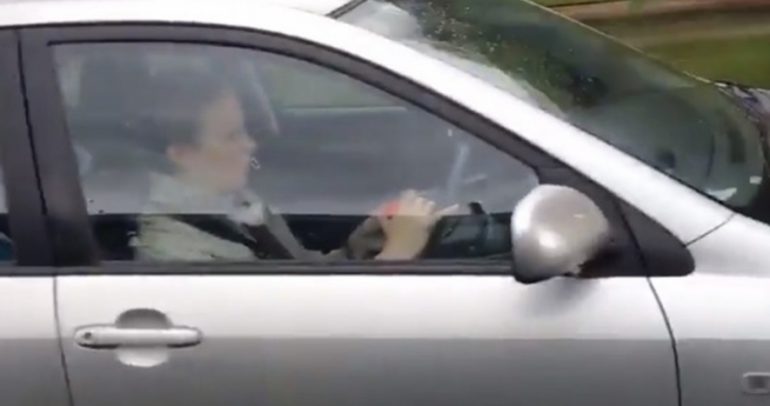 امرأة بريطانية تلعب مكعب روبيك أثناء القيادة